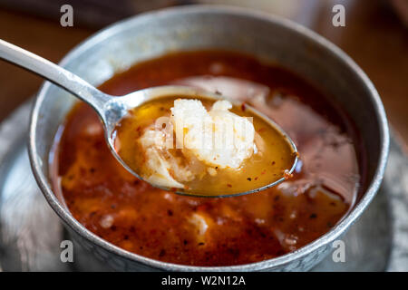 Kelle Paca la zuppa in una ciotola / piastra con il cucchiaio e il limone sul tavolo di legno. Zuppa tradizionale di Gaziantep, Turchia. Famosa cucina turca di alimenti freschi schiume Foto Stock