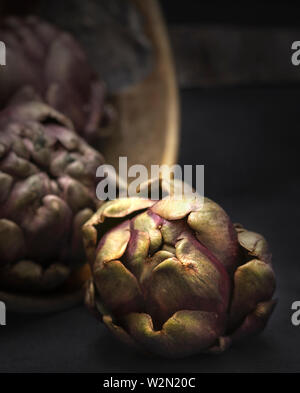 Cibo nature morte di carciofini impostato in un'atmosfera rustica Foto Stock