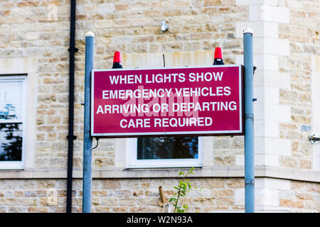 Un segno rosso in Bradford on Avon attenzione agli automobilisti che luci lampeggianti indicano i veicoli di emergenza in partenza o in arrivo e di esercitare la massima cautela. Foto Stock