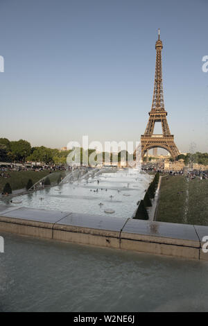 Europa, Francia, Parigi, 2019-06, Torre Eiffel monumento visti dal Trocadero gardins. La gente la balneazione in fontane in uno sforzo per raffreddare duri Foto Stock