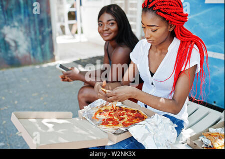 Mani di African American donna con la pizza. Foto Stock