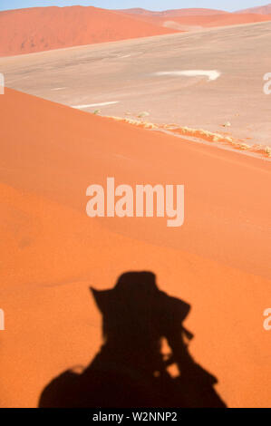 Ombra del fotografo (Amos Gal RIP)su una duna di sabbia ridge al Sossusvlei, Namib-Naukluft National Park, Namibia. Foto Stock