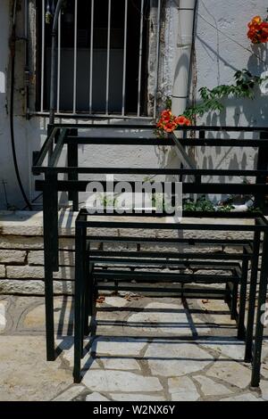 Corfù quadro di metallo in un cortile della chiesa a Kassiopi.sicuri di utilizzare impilati vicino a una finestra sbarrata Foto Stock
