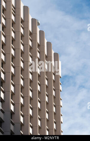 Un'immagine generica di un ufficio di multistory o appartamento torre di cemento e vetro con cielo blu e nuvole bianche Foto Stock