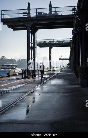 Angolo basso urbanscape di Jones Bay Wharf. North Sydney visibile in attraverso la mattina presto haze in background. Sydney NSW. Giugno 2019 Foto Stock