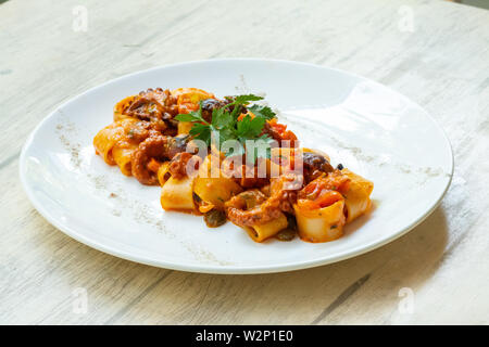 Close up calamarata octopus italiano tradizionale siciliana di pasta fatta in casa la salsa di frutti di mare con pomodoro, basilico, prezzemolo,erbe,piccante preparato mediante la professione Foto Stock