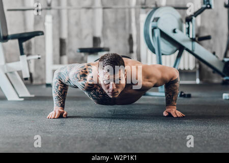 Cool bodybuilder eseguendo Plank in palestra. foto con spazio di copia Foto Stock