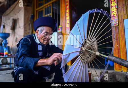 (190710) -- QIUBEI, luglio 10, 2019 (Xinhua) -- Zhang Ronghua rende un olio-ombrello di carta in Xiangyang villaggio di Qiubei County, Zhuang e Miao prefettura autonoma di Wenshan, a sud-ovest della Cina di Provincia di Yunnan, Luglio 9, 2019. Zhang Ronghua, 89 e il nipote Zhang Guoqing sono gli unici eredi della tradizionale olio-ombrello di carta rendendo in Xiangyang Village. Xiangyang Village ha un oltre 400 anni di storia della realizzazione artigianale a carta oliata ombrelloni con gabbie di bambù. Fatta di carta oliata e cornice di bambù, olio-ombrello di carta è un cinese tradizionale artigianato. L'artigianalità ch. Foto Stock