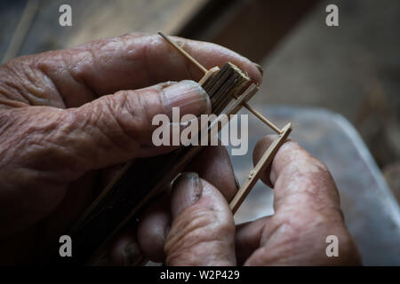 (190710) -- QIUBEI, luglio 10, 2019 (Xinhua) -- Zhang Ronghua rende lo scheletro di un olio-ombrello di carta in Xiangyang villaggio di Qiubei County, Zhuang e Miao prefettura autonoma di Wenshan, a sud-ovest della Cina di Provincia di Yunnan, Luglio 9, 2019. Zhang Ronghua, 89 e il nipote Zhang Guoqing sono gli unici eredi della tradizionale olio-ombrello di carta rendendo in Xiangyang Village. Xiangyang Village ha un oltre 400 anni di storia della realizzazione artigianale a carta oliata ombrelloni con gabbie di bambù. Fatta di carta oliata e cornice di bambù, olio-ombrello di carta è un cinese tradizionale artigianato. Il CRAF Foto Stock