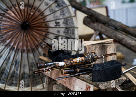 (190710) -- QIUBEI, luglio 10, 2019 (Xinhua) -- Foto scattata il 9 luglio 2019 mostra gli strumenti utilizzati per rendere olio-carta ombrelloni in Xiangyang villaggio di Qiubei County, Zhuang e Miao prefettura autonoma di Wenshan, a sud-ovest della Cina di Provincia di Yunnan. Zhang Ronghua, 89 e il nipote Zhang Guoqing sono gli unici eredi della tradizionale olio-ombrello di carta rendendo in Xiangyang Village. Xiangyang Village ha un oltre 400 anni di storia della realizzazione artigianale a carta oliata ombrelloni con gabbie di bambù. Fatta di carta oliata e cornice di bambù, olio-ombrello di carta è un cinese tradizionale artigianato. Il CRA Foto Stock