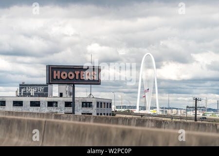 Dallas, Stati Uniti d'America - 7 Giugno 2019: vista dall'autostrada in città a Woodall Rodgers Freeway e il famoso ponte e Hooters segno Foto Stock