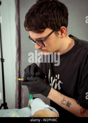 Tatuaggio caucasica artista nei suoi studi di tatuaggio un tatuaggio minimalista Foto Stock