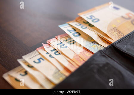 Aprire il portafoglio con un sacco di valuta euro banknites sporgente. Le persone ricche concetto. Denaro piano di investimenti. Come spendere il denaro in maniera saggia Foto Stock