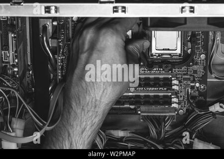 Maykop, Russia - 17 Settembre 2016: Maschio lato installa un processore Intel processore nel socket della scheda madre, foto in bianco e nero Foto Stock