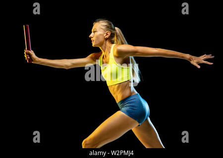 Professional relè femmina racer isolato di formazione su nero di sfondo per studio in luce al neon. Donna in sportsuit praticanti in esecuzione. Uno stile di vita sano, sport, allenamento, motion, concetto di azione. Foto Stock