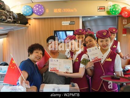 (190710) -- TIANJIN, luglio 10, 2019 (Xinhua) -- Hostess presente negozio di souvenir per i passeggeri del treno proiettile G305 sulla luglio 10, 2019. Trasportano più di 1.100 passeggeri, il bullet train G305 partì di Tianjin al 10:58 a.m. e arriverà a Hong Kong West Kowloon Station circa dieci ore più tardi, secondo la Tianjin dell autorità ferroviarie. La 2.450 km-lungo il percorso verranno eseguiti attraverso diverse stazioni comprese stazione Baiyangdian nel Xiongan nuova Area. Una seconda classe di sede per la 10 ore di viaggio avrà un costo 1,092.5 yuan (circa 159 dollari). (Xinhua/Xing Guangli) Foto Stock