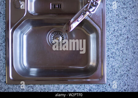 Vista dall'alto il ripiano del bancone in marmo e lavello da cucina sfondo con copia spazio per il testo. Chrome lavello da cucina in un professionista di cucina moderna Foto Stock