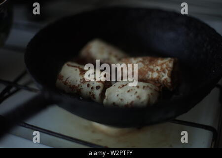 Pancake bobine vengono fritti in padella. Il russo tradizionale piatto Foto Stock