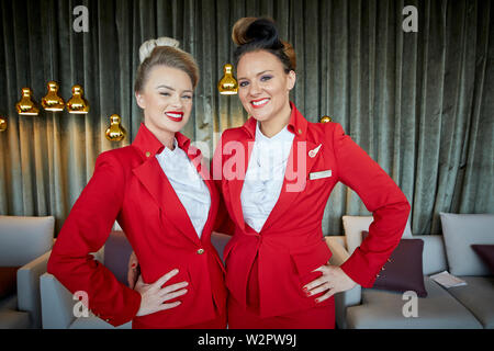 Posti Virgin Atlantic equipaggio di cabina Air hostess in rosso uniforme Foto Stock