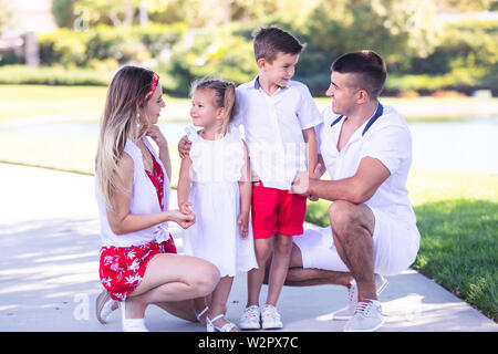 La famiglia felice divertirsi insieme nel bellissimo parco Foto Stock