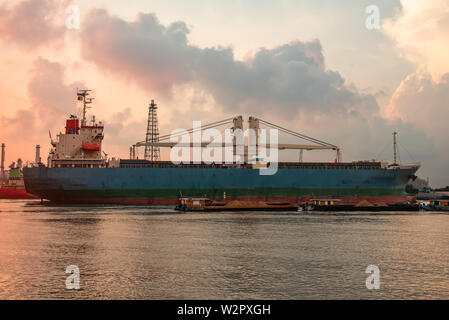 Grandi navi che trasportano contenitori con commercio estero, il trasporto di merci e macchinari per il porto di Fiume Chao Phraya. Foto Stock