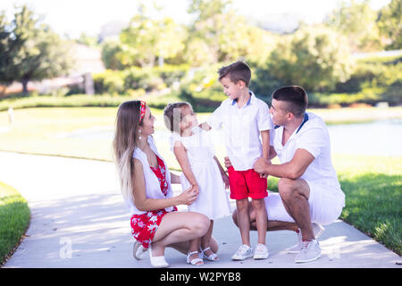 La famiglia felice divertirsi insieme nel bellissimo parco Foto Stock