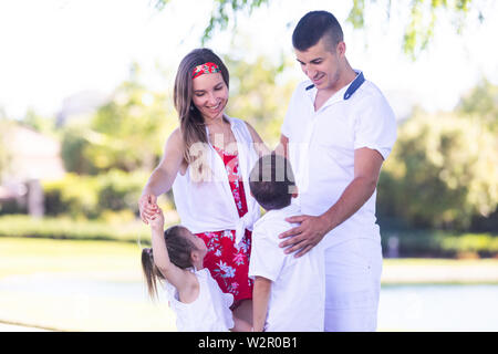 La famiglia felice divertirsi insieme nel bellissimo parco Foto Stock