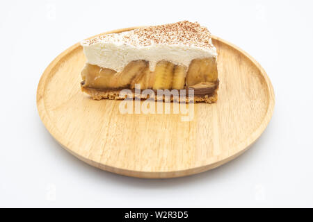 Banoffee Pie, panna montata e banana sul piatto di legno isolare lo sfondo bianco Foto Stock