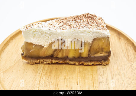 Banoffee Pie, panna montata e banana sul piatto di legno isolare lo sfondo bianco Foto Stock