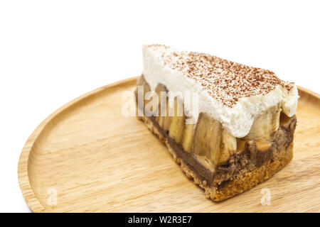 Banoffee Pie, panna montata e banana sul piatto di legno isolare lo sfondo bianco Foto Stock