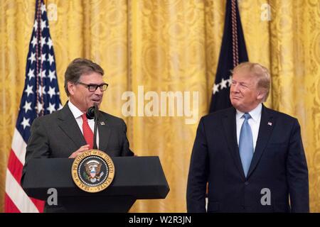 U.S presidente Donald Trump ascolta come segretario dell'energia Rick Perry indirizzi commento sulla Leadership ambientale nella Sala Est della Casa Bianca Luglio 8, 2019 a Washington, DC. Foto Stock