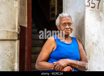 Vecchia Havana, Cuba - Gennaio 2, 2019: un senior Afro-cubano sta femmina al di fuori del suo appartamento casa nella Vecchia Havana, Cuba. Foto Stock