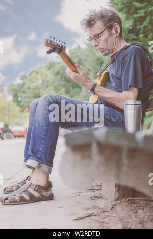 I vecchi musicista maschio a suonare la chitarra su un New York City Street Foto Stock