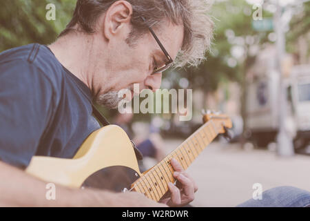 I vecchi musicista maschio a suonare la chitarra su un New York City Street Foto Stock