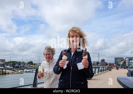 Littlehampton West Sussex Regno Unito - donna anziana e figlia gustare un gelato cornet Foto Stock