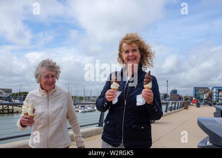 Littlehampton West Sussex Regno Unito - donna anziana e figlia gustare un gelato cornet Foto Stock