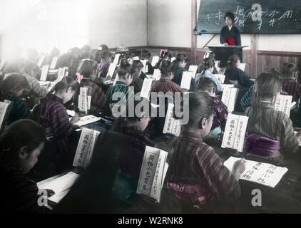 [ 1900 Giappone - Gli studenti della scuola elementare ] - Giapponese gli studenti della scuola elementare che studiano la scrittura in un'aula. Questa immagine è parte di "La vita della scuola di giovani Giappone " (n. 4), una serie pubblicata dal fotografo giapponese Kozaburo Tamamura nei primi anni del Novecento (fine Meiji). Testo originale: "Ragazze di circa la stessa età, studiando 'calligrafia". N.B.-la scrittura giapponese con un pennello, ad eccezione di quando si impara a scrivere in inglese.' xx secolo vintage vetrino di vetro. Foto Stock