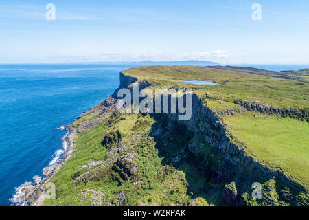 Fair Head big cliff e operazioni automatiche di fine campo all'angolo nord-est della Contea di Antrim, Irlanda del Nord, Regno Unito. Vista aerea con l'Oceano Atlantico e un lago. Foto Stock