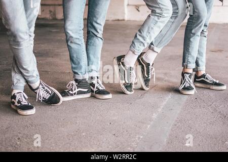 Primo piano di un gruppo di persone che indossano la vecchia scuola furgoni neri e jeans blu Foto Stock