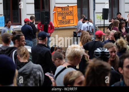 Leipzig, Germania. 10 Luglio, 2019. I partecipanti di una dimostrazione di raccogliere su di una strada nella zona est della città. Diverse centinaia di persone si sono radunate per protestare contro la deportazione di Siriano alla Spagna la notte prima. Il tentativo di deportare i manifestanti hanno portato a scontri tra manifestanti e forze di polizia. Credito: Sebastian Willnow/dpa-Zentralbild/dpa/Alamy Live News Foto Stock