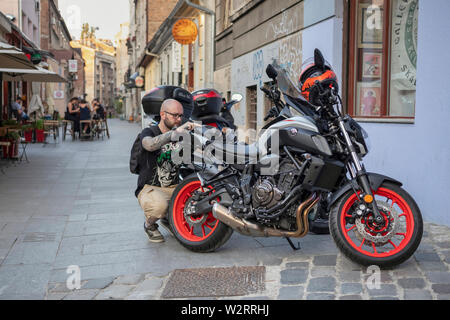 A Belgrado, in Serbia il 5 Luglio 2019: scena urbana con uomo a prepararsi per un giro in moto Foto Stock