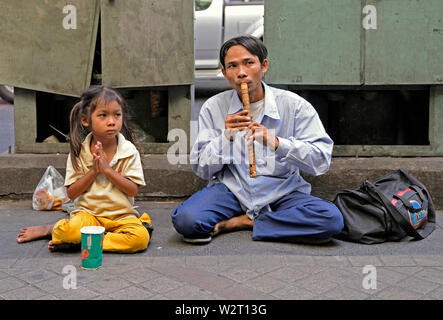 Bangkok, Tailandia - 15 gennaio 2011: un ragazzo e una ragazza mendicante su thanon silom sotto la stazione bts skytrain sala daeng Foto Stock