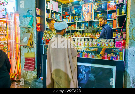 KASHAN, IRAN - 23 ottobre 2017: il piccolo mercato turistico mullah (chierico islamico) scegliere il profumo in stallo del Grand Bazaar, il 23 ottobre a Kashan Foto Stock