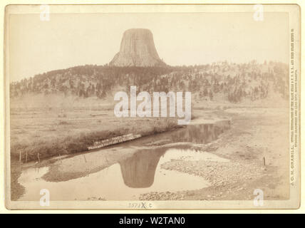 Devil's Tower; vista in lontananza Devils Tower e riflessione della torre nel flusso in primo piano. Foto Stock