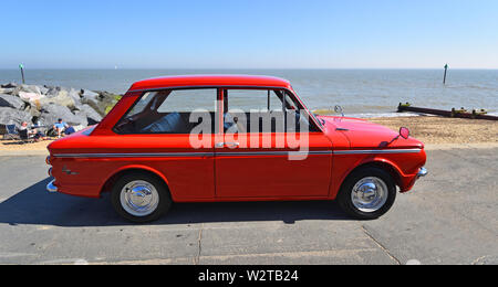 Rosso classico Hillman Imp automobile parcheggiata sul lungomare. Foto Stock