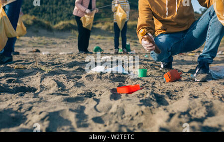Giovane uomo pulizia della spiaggia Foto Stock