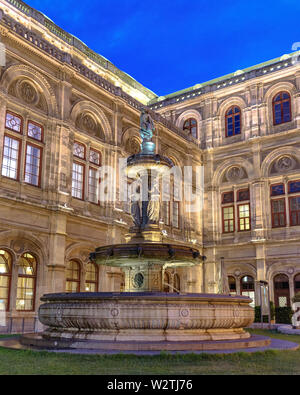 La fontana Opernbrunzer prima dell'Opera di Stato di Vienna al blue ora in estate Foto Stock