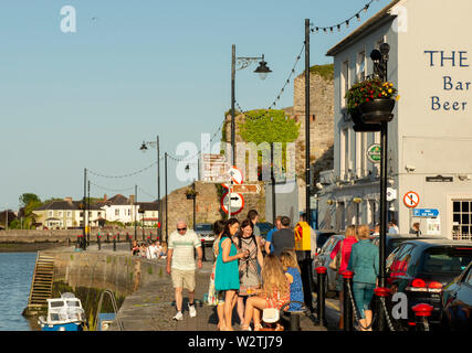 Le persone che chiacchierano godendosi il tardo pomeriggio al Davitt's Quay a Dungarvan, County Waterford, Irlanda Foto Stock