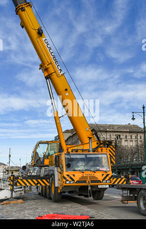 BUDAPEST, UNGHERIA - Marzo 2018: un ampio angolo di visione di una grande gru mobile con braccio telescopico esteso sul lungofiume di Budapest. Foto Stock