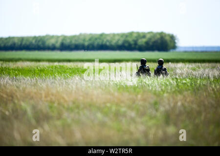 Boboc, Romania - 22 Maggio 2019: romeno esercito pattuglia di soldati in un campo su una soleggiata giornata estiva durante un drill. Foto Stock